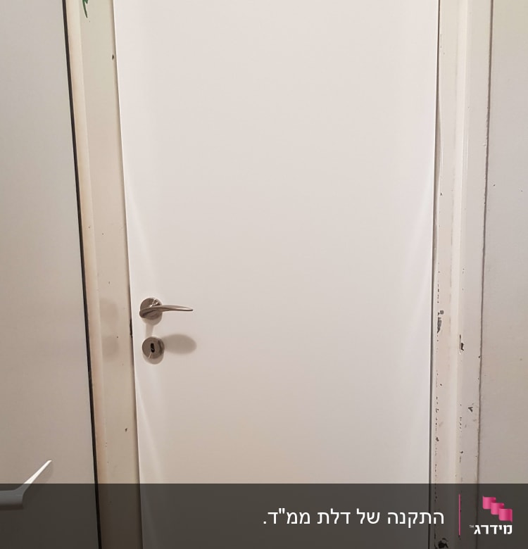 דלת לבנה עם ידית מתכת כסופה